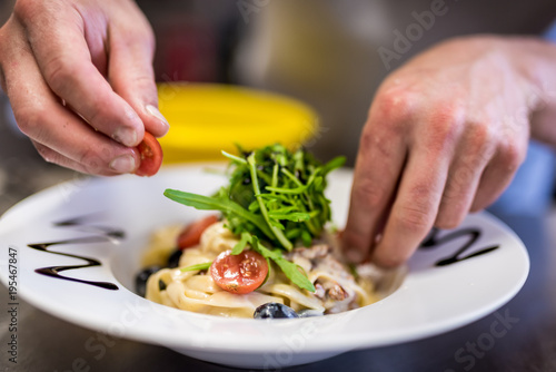 Close-up of chef's hands, preparation of salad in the kitchen, traditional Italian dishes