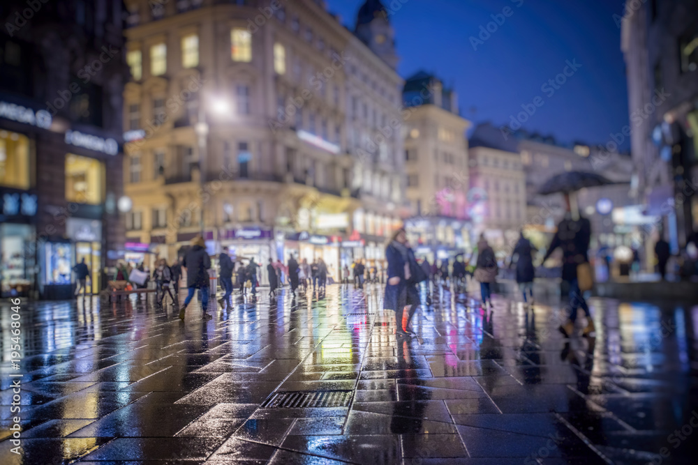people walking on rainy night in the city 