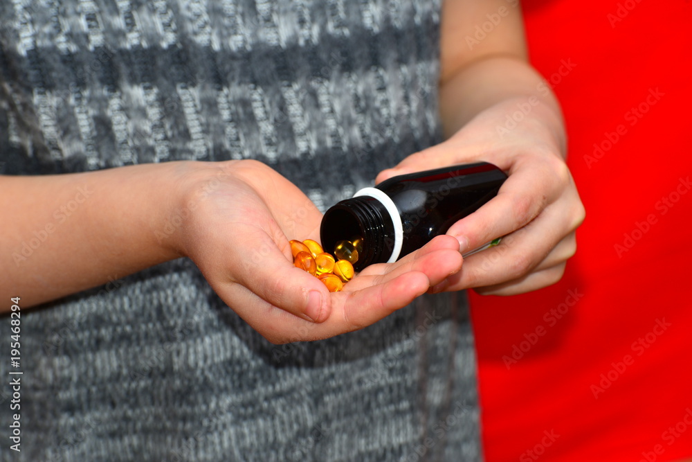 The girl takes out the yellow tablets from the jar. The concept of business, health and prosperity. The girl takes out the yellow tablets from the jar. The concept of business, health and prosperity.