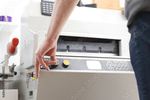 Drukarz. Pracownik obsługuje maszynę drukującą.