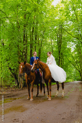 Beautiful newlyweds riding two horses