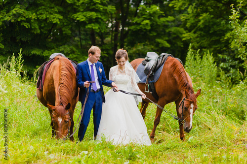 Beautiful newlyweds with two horses
