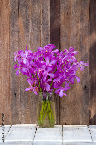Bouquets orchid flowers in the tropical yard on a wooden table