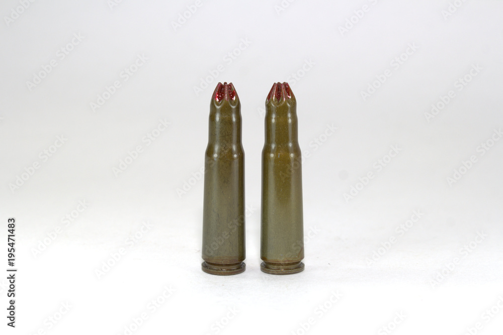 two blank cartridges for a Kalashnikov assault rifle on white background close-up two blank cartridges for a Kalashnikov assault rifle on white background close-up