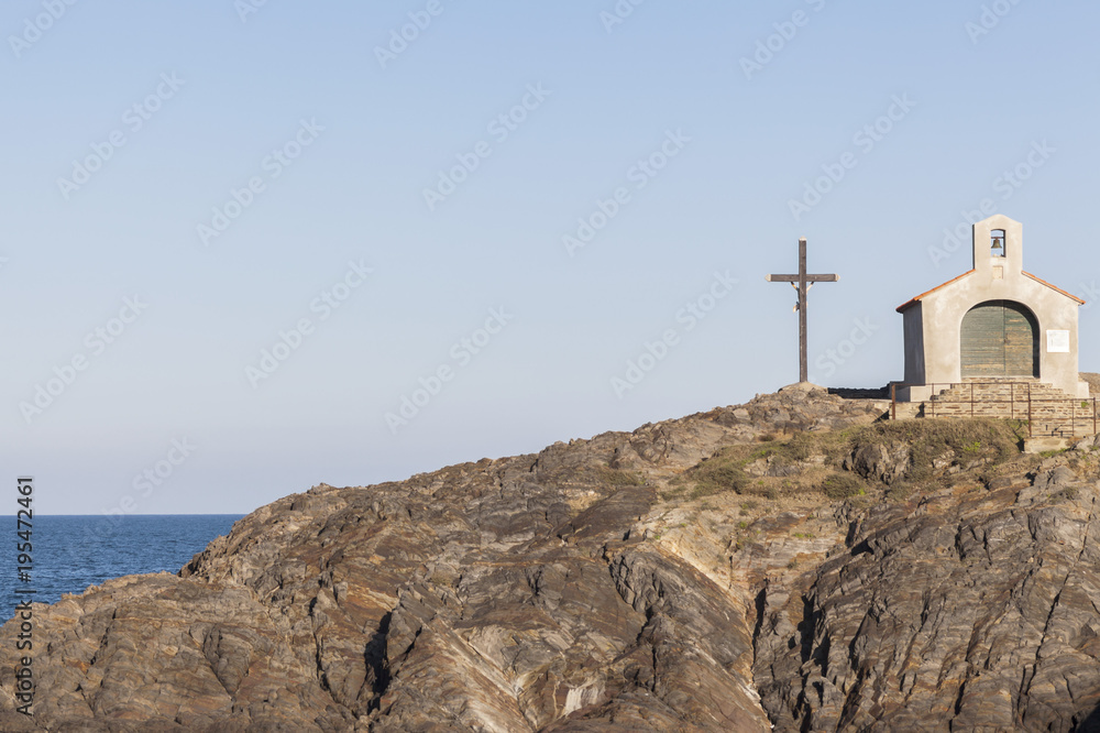 Ancient chapel and cross, rock formation and sea, Collioure, Cote Vermeille, Occitanie, France.