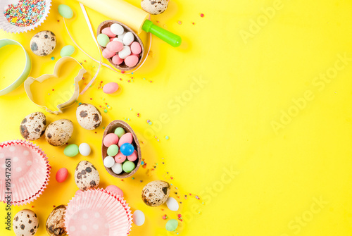 Sweet baking concept for Easter, cooking background with baking - with a rolling pin, whisk for whipping, cookie cutters, quail eggs, sugar sprinkling. Bright yellow background, top view copy space