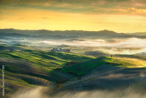 Volterra foggy panorama, rolling hills and green fields on sunset. Tuscany, Italy © stevanzz