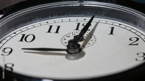 Closeup on slowly rotating clock face with fast moving clock hands - time running out concept, timelapse