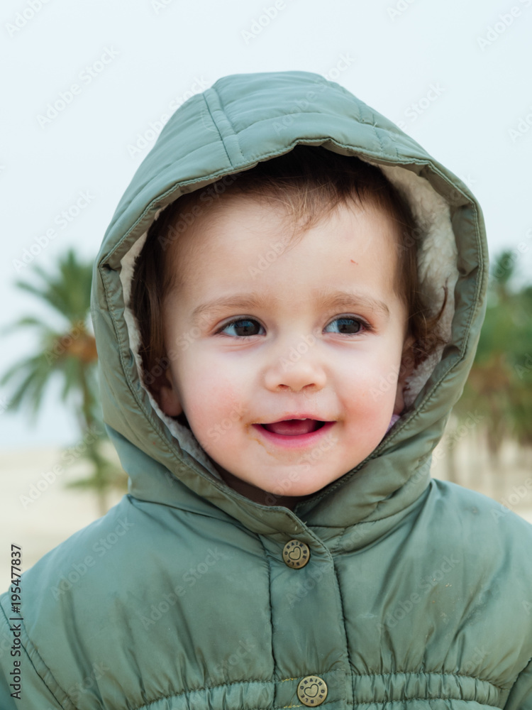 portrait of a 2 year old girl with a hood of her jacket portrait of a 2 year old girl with a hood of her jacket