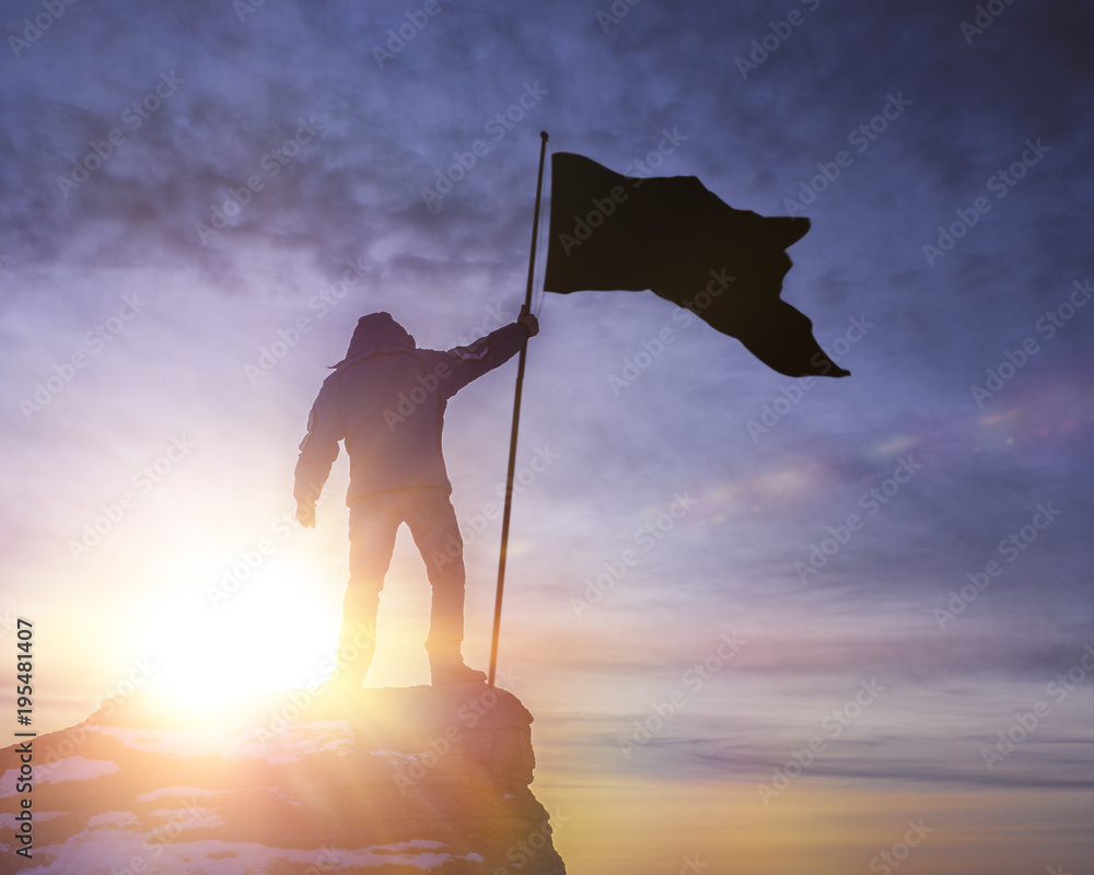 silhouette of man with flag of victory on top of a mountain over sky ...