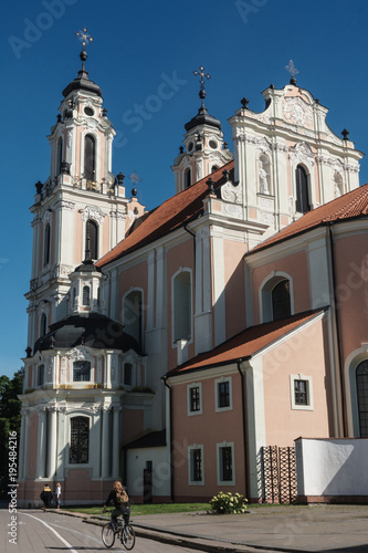 Cyclist passes by strawberry and cream Baroque Church of St Catherine, Old Town, UNESCO Wolrd Heritage Site, Vilnius, Lithuania photo