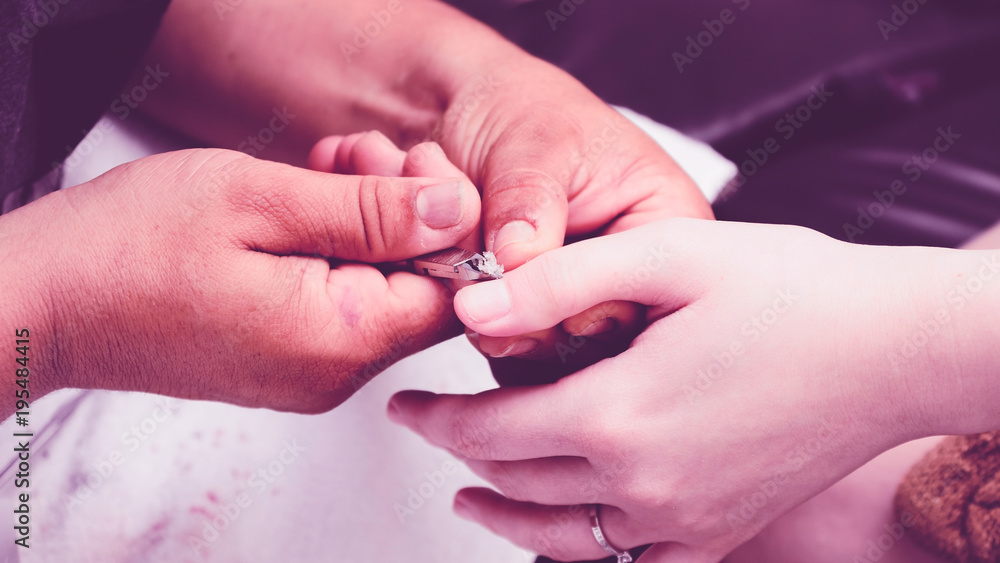 Manicurist using pliers to remove dead skin from around the client fingers. Manicurist using pliers to remove dead skin from around the client fingers.