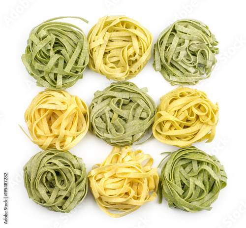 Fettuccine pasta raw (nine spinach and classic) isolated on white background top view. photo