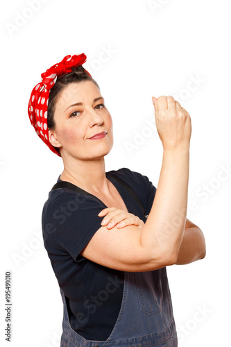 Self-confident middle aged woman with dungarees isolated on white background, text space, tribute to american worker icon Rosie Riveter.