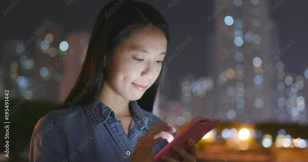 Woman looking at mobile phone at night Woman looking at mobile phone at night