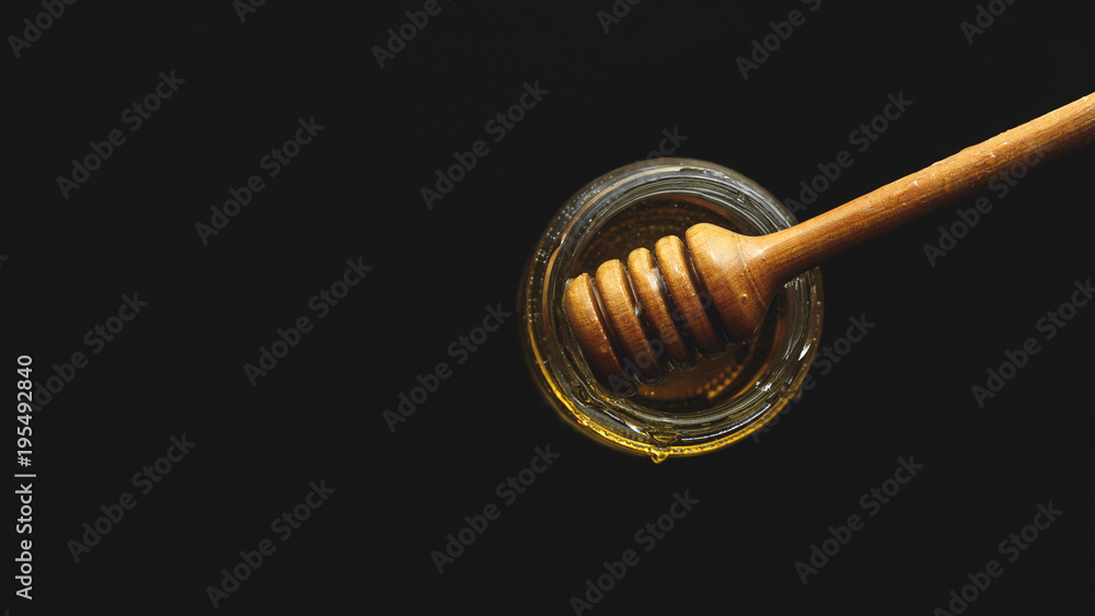 Honey jar with dipper and flowing honey Honey jar with dipper and flowing honey