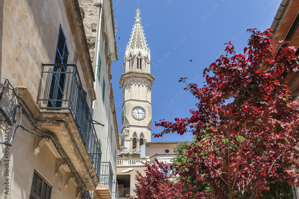 Village view, facade building, flowers and tower church, historic center of Manacor, Mallorca Island, Balearic Islands.Spain.
