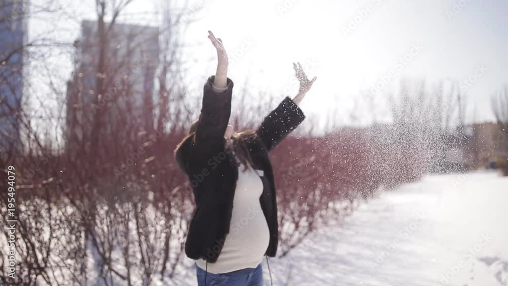 A beautiful and cute girl with dark long hair wearing glasses walking winter park. She smiles and is happy playing snow. A beautiful and cute girl with dark long hair wearing glasses walking winter park. She smiles and is happy playing snow.