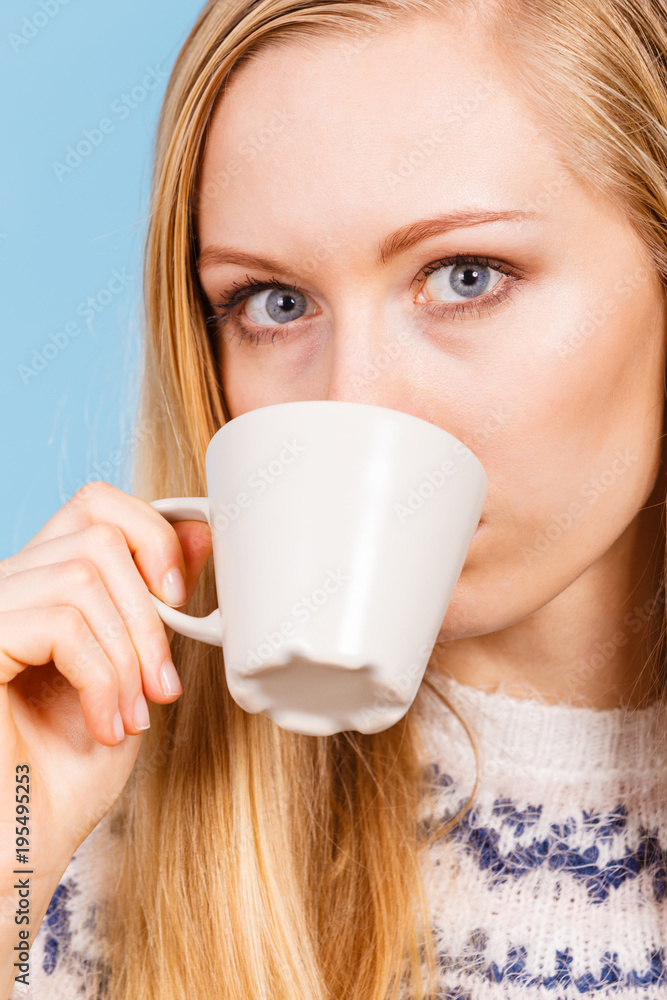 Blonde woman drinking hot drink from cup Blonde woman drinking hot drink from cup