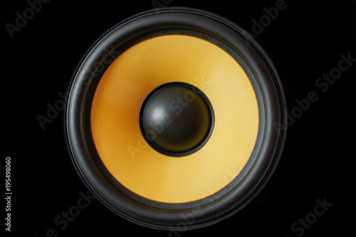 Subwoofer dynamic membrane or sound speaker isolated on black background, yellow Hi-Fi loudspeaker close up photo