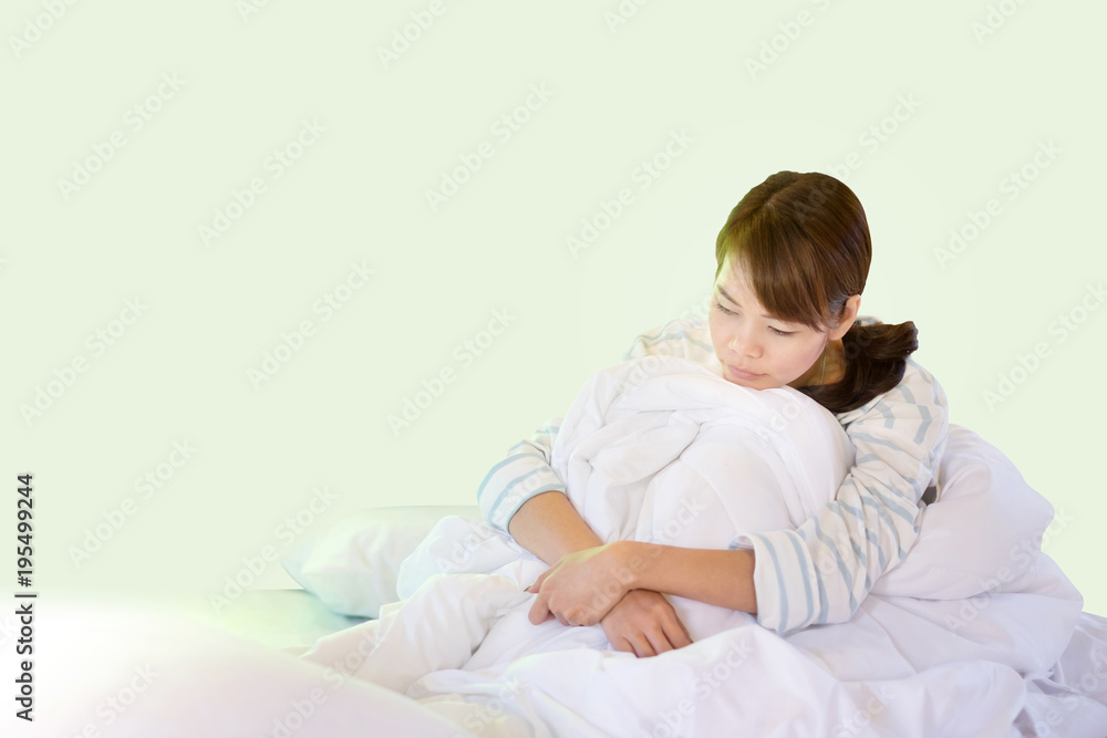Fototapeta premium Sad Asian Woman Sitting On Her White Bed While Waking Up