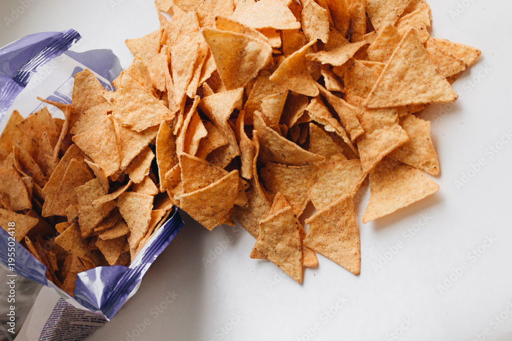 Pile of delicious crispy nachos of out pack on white background, traditional Mexican cuisine Pile of delicious crispy nachos of out pack on white background, traditional Mexican cuisine