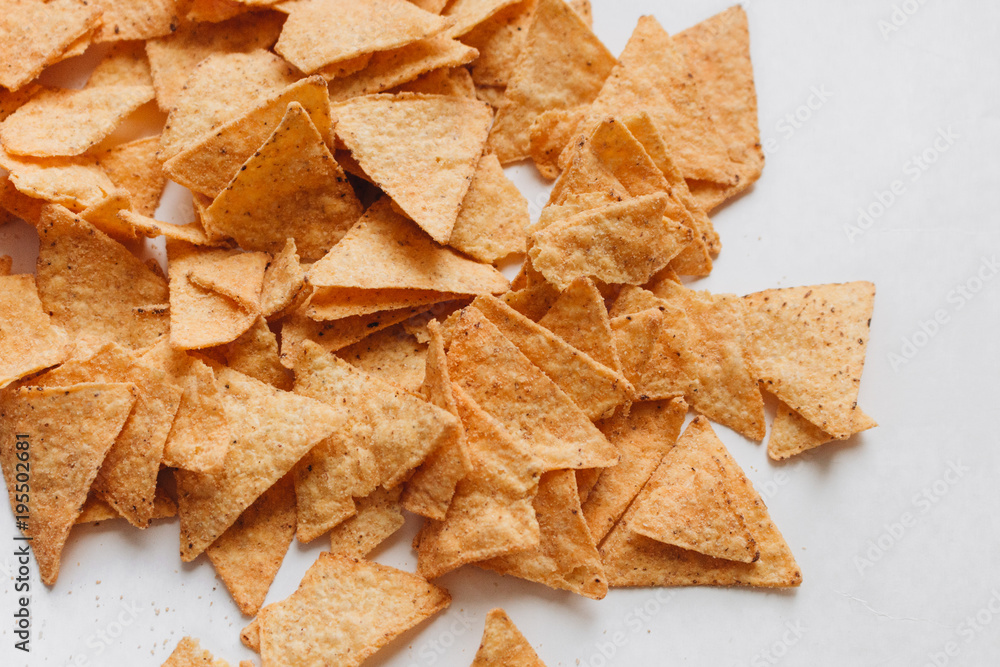 Pile of delicious crispy nachos of out pack on white background, traditional Mexican cuisine Pile of delicious crispy nachos of out pack on white background, traditional Mexican cuisine