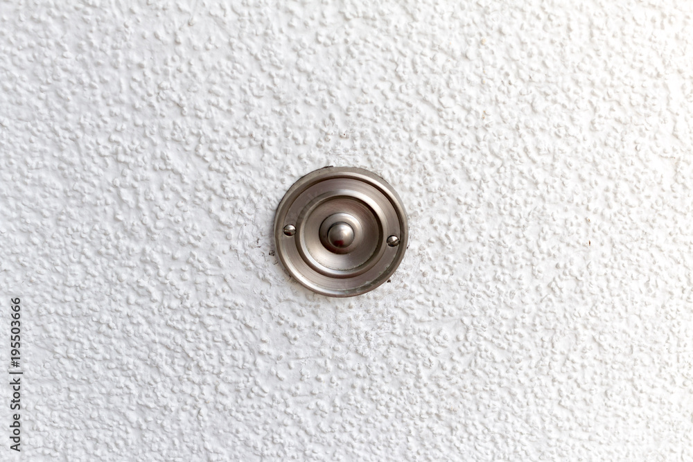 Edelstahl Türklingel an einer weissen Wand Edelstahl Türklingel an einer weissen Wand