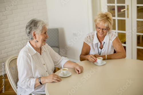 Two older women drinking co...