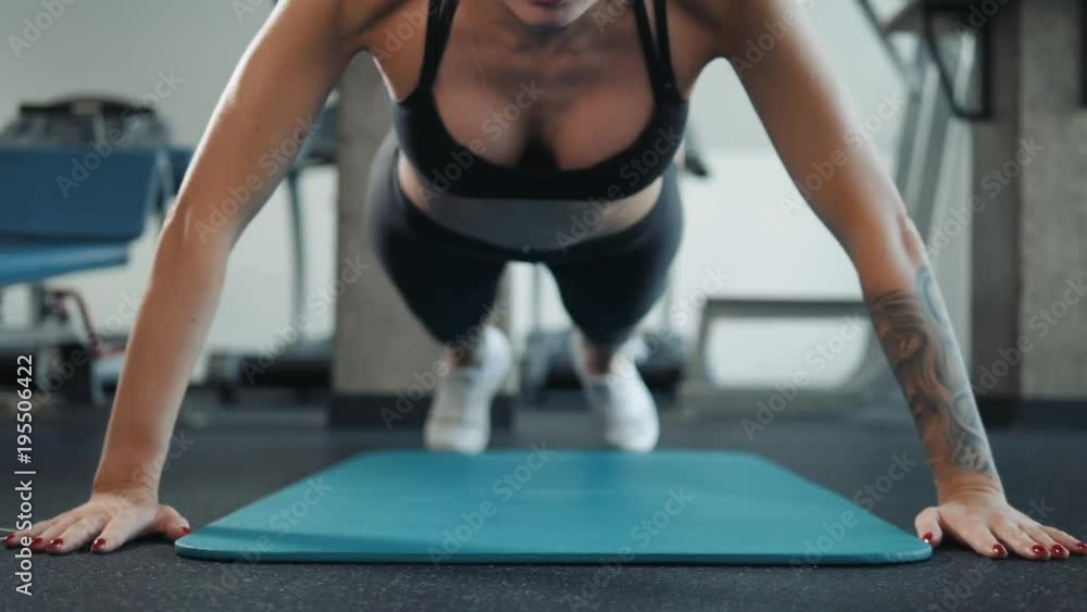Beautiful slim brunette doing some push ups a the gym woman sport athlete Beautiful slim brunette doing some push ups a the gym woman sport athlete