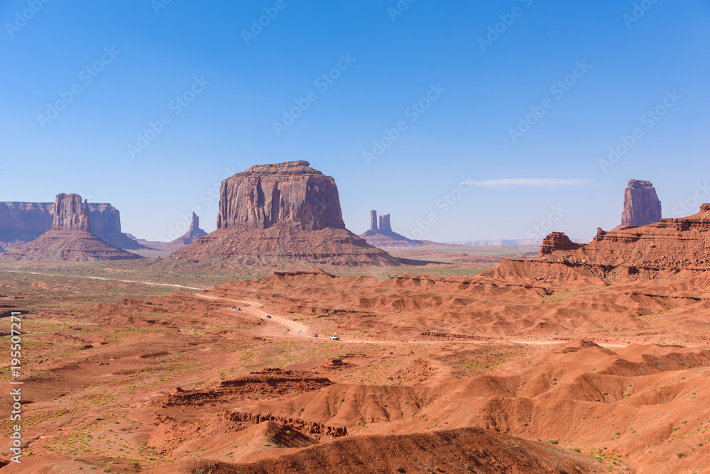 Scenic Drive on Dirt Road through Monument Valley, The famous Buttes of Navajo tribal Park, Utah - Arizona, USA. Scenic road and red rock formations.