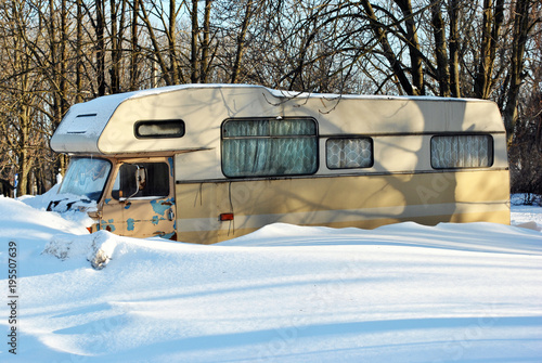 Old trailer in snowy park, winter sunny day in Ukraine