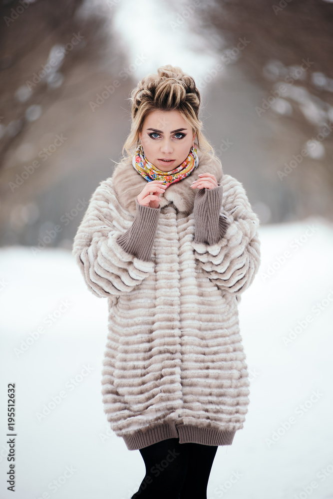 Beautiful girl in fur coat in winter in the forest Beautiful girl in fur coat in winter in the forest