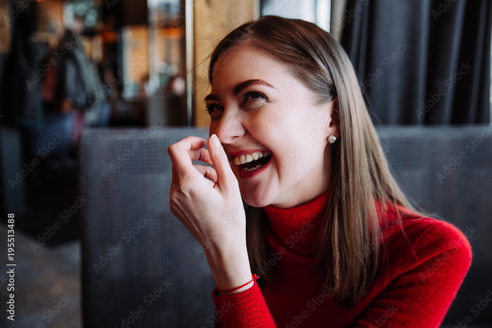 portrait of a beautiful brunette in a red turtleneck who laughs portrait of a beautiful brunette in a red turtleneck who laughs