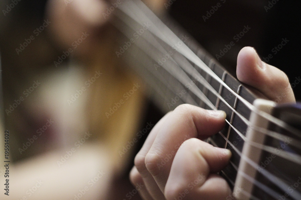 the hand on the background of the acoustic guitar