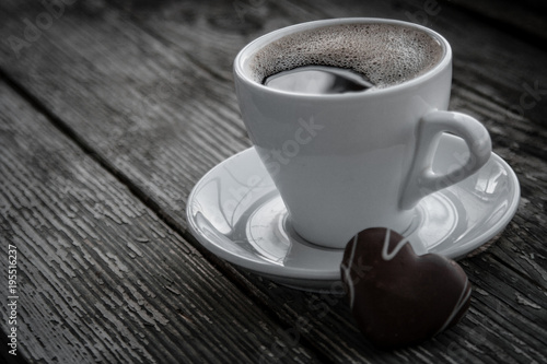 White cup of coffee on a natural old wooden background with biscuits. Selective focus. With copy space