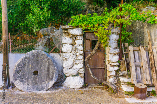 An old door and a millstone at Arginia, a remote village in mountain Ainos in the southern side of Cephalonia island in Greece