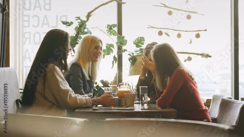 company friends talking in a cafe and having fun photo