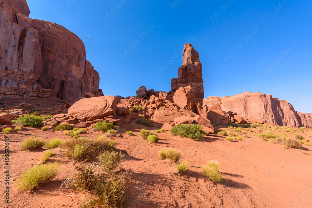 Fototapeta premium Scenic Drive on Dirt Road through Monument Valley, The famous Buttes of Navajo tribal Park, Utah - Arizona, USA. Scenic road and red rock formations.