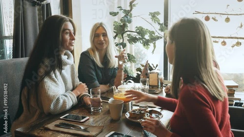 Four female friends enjoying in talking at cafe