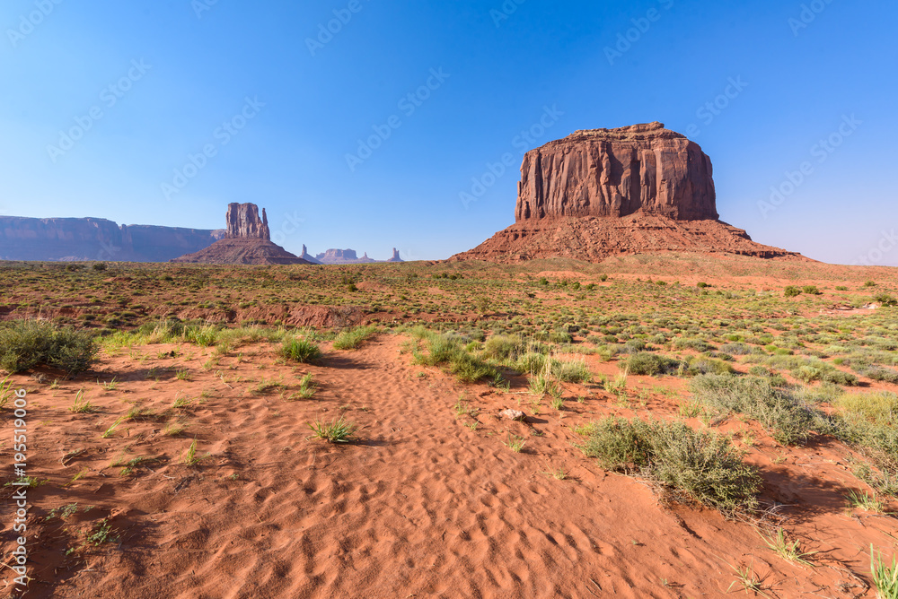 Scenic Drive on Dirt Road through Monument Valley, The famous Buttes of Navajo tribal Park, Utah - Arizona, USA. Scenic road and red rock formations. Scenic Drive on Dirt Road through Monument Valley, The famous Buttes of Navajo tribal Park, Utah - Arizona, USA. Scenic road and red rock formations.
