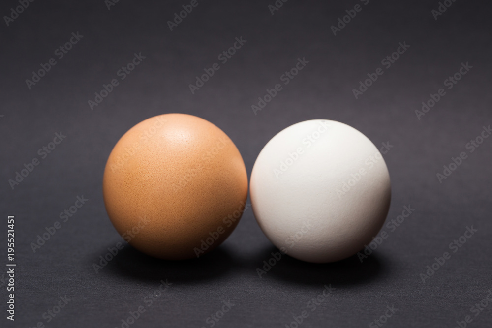 White and yellow egg on a black background. Close-up.