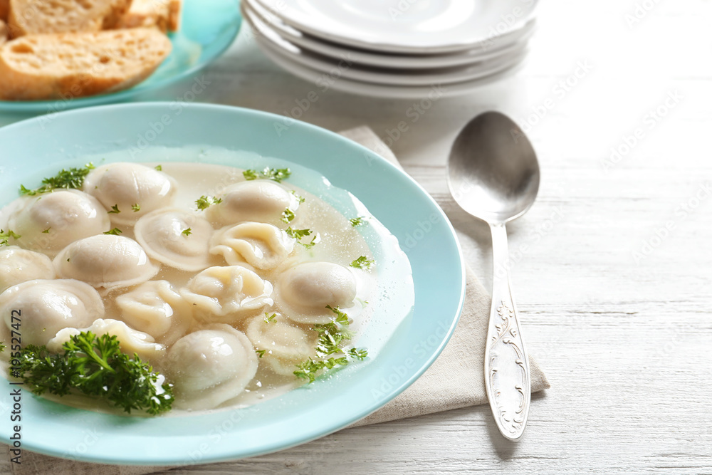 Tasty broth with dumplings on wooden table Tasty broth with dumplings on wooden table