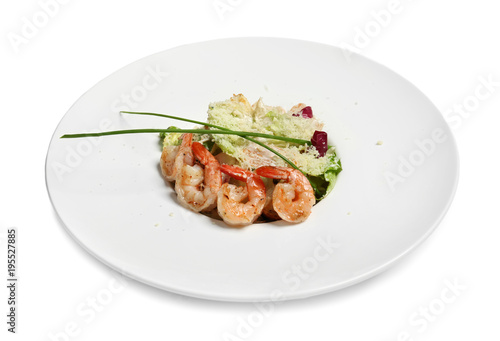 Delicious Caesar salad with shrimps in plate on white background