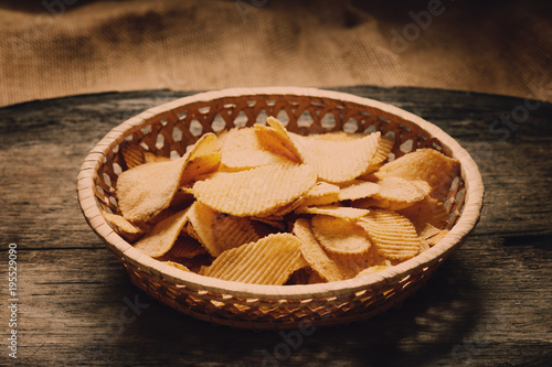 Crispy potato chips in a wicker dish