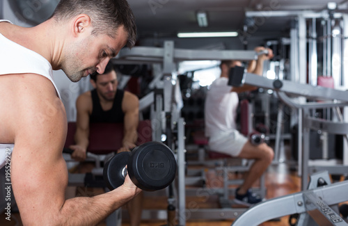 Guy during workout in gym with dumbbells