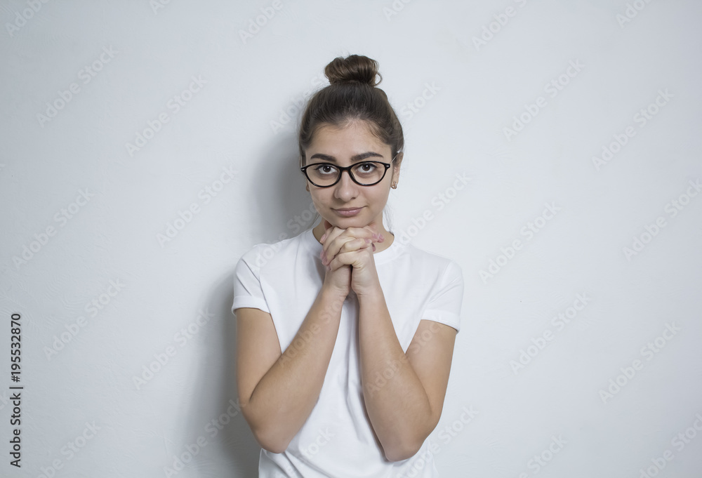 Beautiful thoughtful brunette girl in glasses. The Indian woman thinks, reflects on something on a white background. Beautiful thoughtful brunette girl in glasses. The Indian woman thinks, reflects on something on a white background.