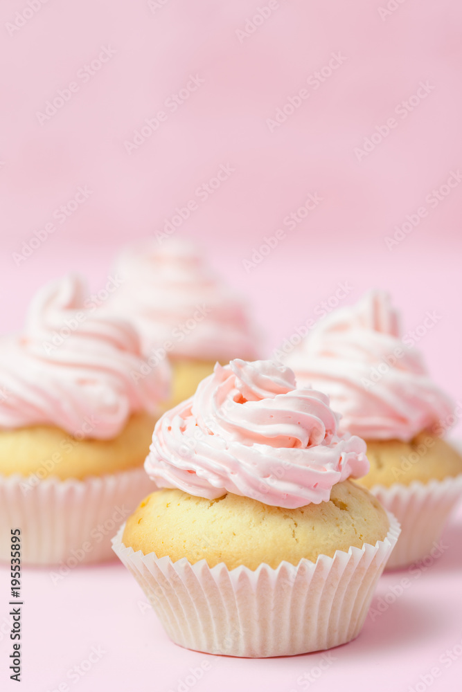 Cupcake decorated with pink buttercream on pastel pink background. Sweet beautiful cake. Vertical banner, greeting card for birthday, wedding, women's day. Close up photography. Selective focus