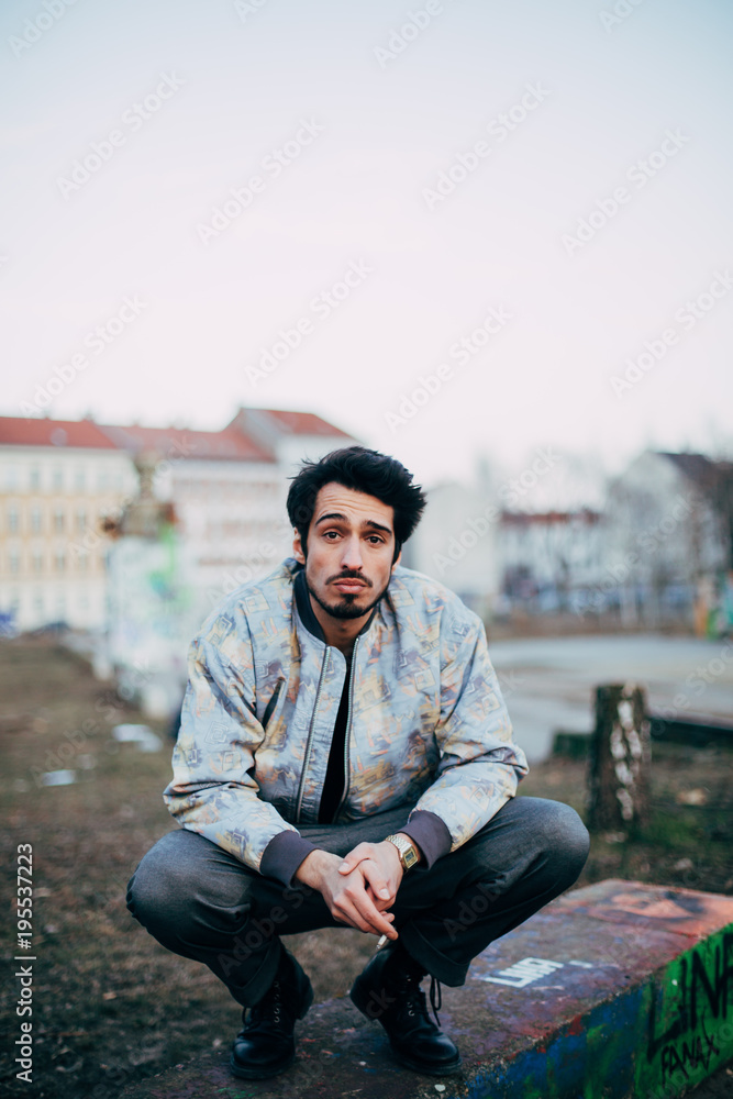 Obraz premium portrait of young cool arab man smoking outdoors in urban environment