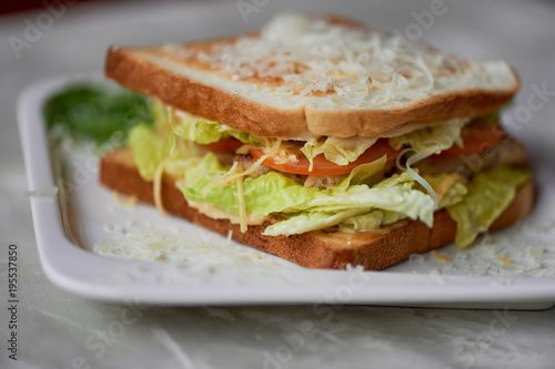 A delicious sandwich with salad and chicken. Sprinkled with cheese. A quick delicious Breakfast